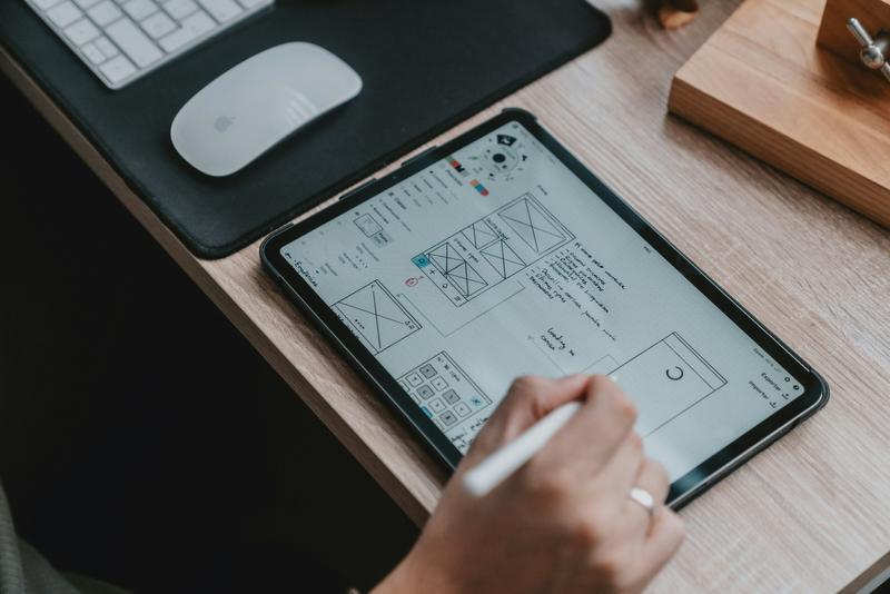 Tablet on a desk next to a desktop computer