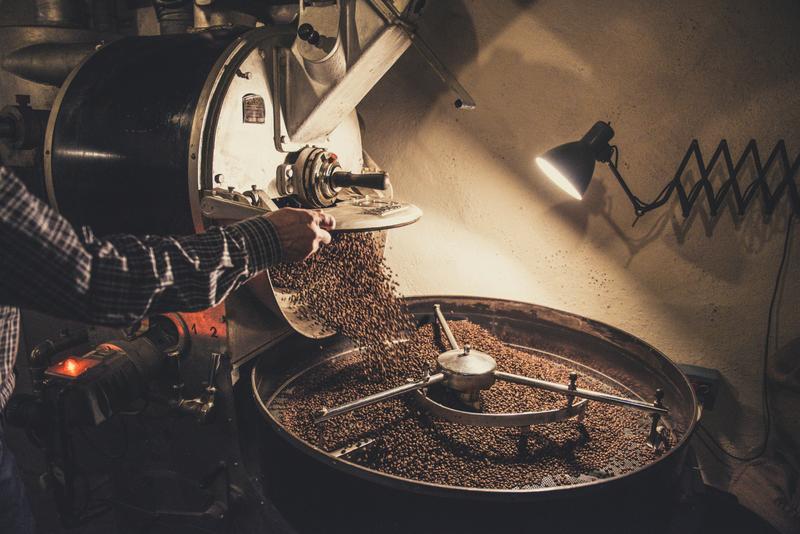 Person pouring coffee beans into a machine