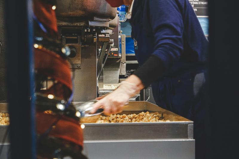 Person in blue handling brown food