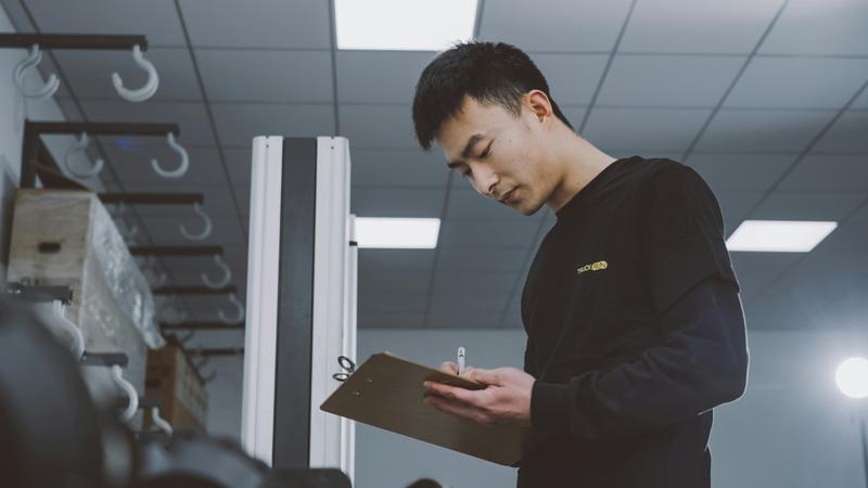 A man in a room holding a clipboard