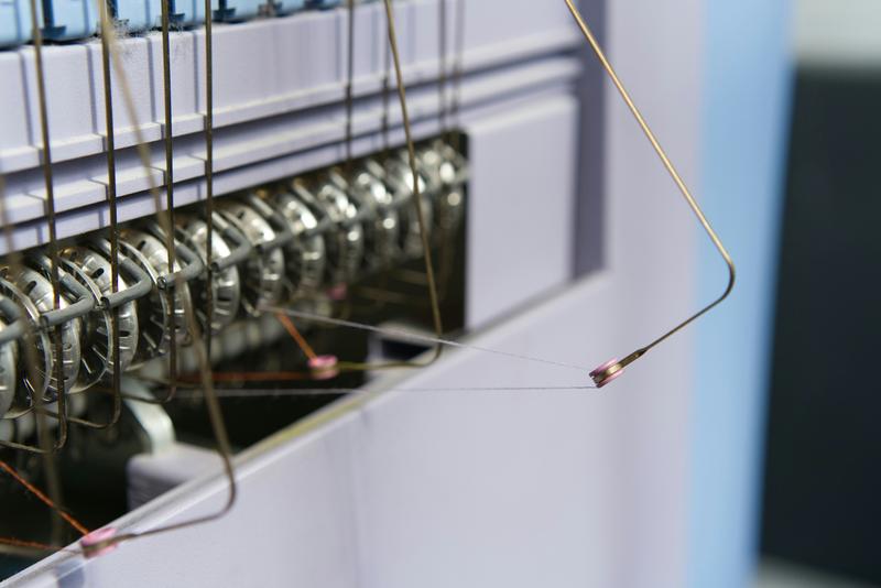 Close-up of a sewing machine with threads